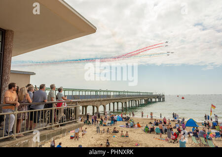 Bournemouth, Dorset, Großbritannien, Samstag, 1.. September 2018. Menschenmassen beobachten vom Strand und vom Pier aus, wie die roten Pfeile beim Bournemouth Air Festival am Boscombe Pier vorbeifliegen. Stockfoto