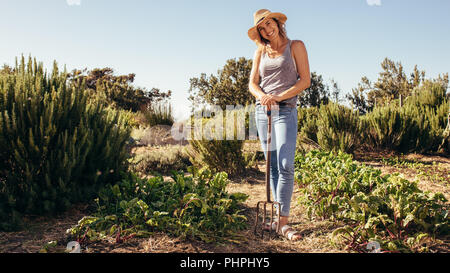 Porträt der schönen Frau Bauer mit Heugabel stehend auf dem Feld. Frau in Ihrer Arbeitsgruppe Stockfoto