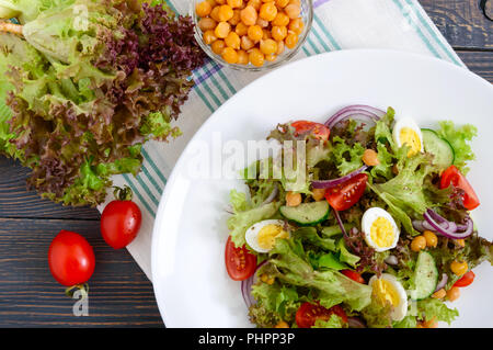 Ernährung, Vegetarische Salat mit wachteleier, frische Kräuter, Kichererbsen, rote Zwiebeln und Tomaten. Stockfoto
