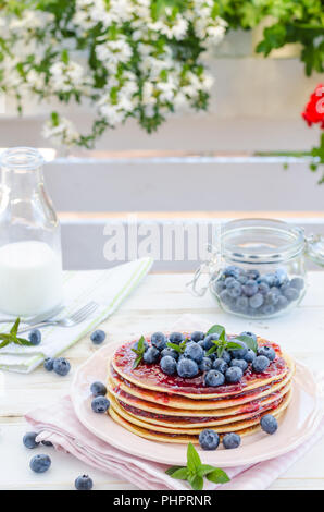 Delish Frühstück mit frischem Obst bei der Gartenparty, aussen mit Blumen hinter und frischen Kräutern auf der Oberseite Stockfoto