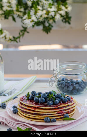 Delish Frühstück mit frischem Obst bei der Gartenparty, aussen mit Blumen hinter und frischen Kräutern auf der Oberseite Stockfoto