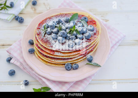 Delish Frühstück mit frischem Obst bei der Gartenparty, aussen mit Blumen hinter und frischen Kräutern auf der Oberseite Stockfoto