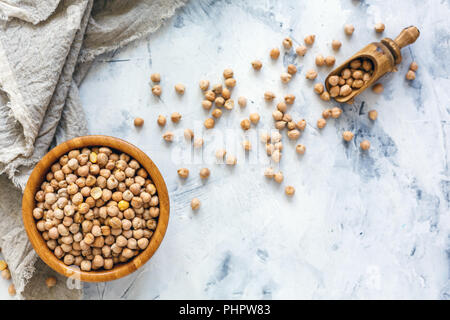 Trockene Kichererbsen in eine hölzerne Schüssel und Leinen. Stockfoto