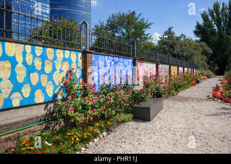 Wand mit Wandmalereien und Gasse in einem Park mit Blumen im Museum des Warschauer Aufstandes, Warschau, Polen Stockfoto