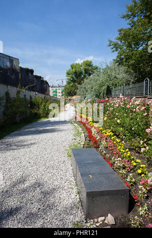 Wand mit Wandmalereien und Gasse in einem Park mit Blumen im Museum des Warschauer Aufstandes, Warschau, Polen Stockfoto