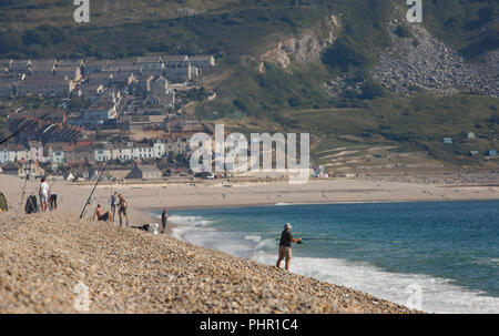 Auf der Suche nach Osten am Nachmittag in Richtung Chesil Bucht mit der Isle of Portland als Kulisse mit angler angeln am Chesil Beach. Dorset England UK Stockfoto