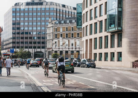 London, Großbritannien - 24 Juli, 2018: Radfahrer und Taxis auf einer Straße in der City von London, London, UK, berühmten Londoner Financial District. Stockfoto