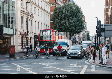 London, Großbritannien - 24 Juli, 2018: Radfahrer, Autos und Busse warten auf grünes Licht auf der Oxford Street Kreuzung, eine große Straße in der Stadt von Westminster in Stockfoto