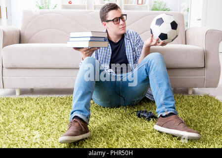 Junge Studenten, die versuchen, zu studieren und spielen Fußball Stockfoto