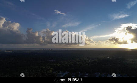 Drone Ansicht der Sonne durch die Wolken in der Nähe der Küste Stockfoto
