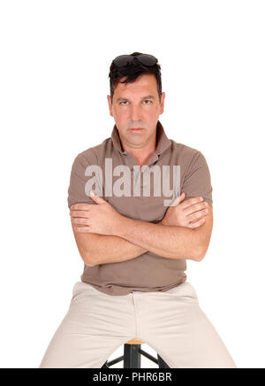 Ernsthafte suche Mann sitzt mit verschränkten Armen Stockfoto