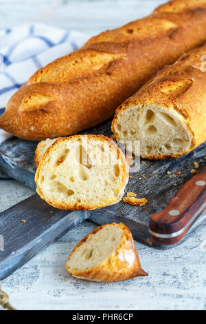 Handwerkliche Baguette in Scheiben geschnitten auf dem Schneidebrett. Stockfoto