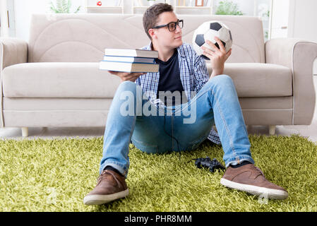 Junge Studenten, die versuchen, zu studieren und spielen Fußball Stockfoto