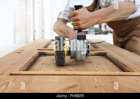 Carpenter das Holz mit dem Schleifer schleifen Elektrowerkzeuge für rustikale Holz- Effekte arbeiten Stockfoto