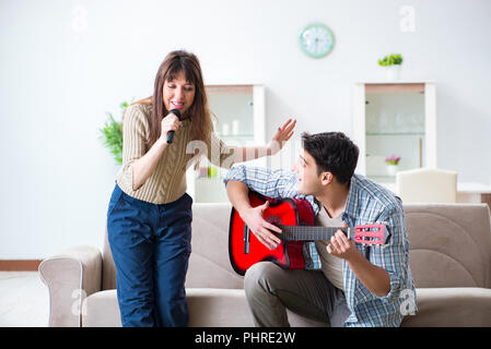 Junge Familie Singen und Spielen zu Hause Musik Stockfoto