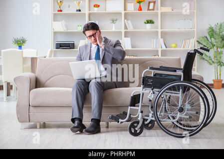 Dsabled Geschäftsmann auf Rollstuhl arbeiten Home Stockfoto