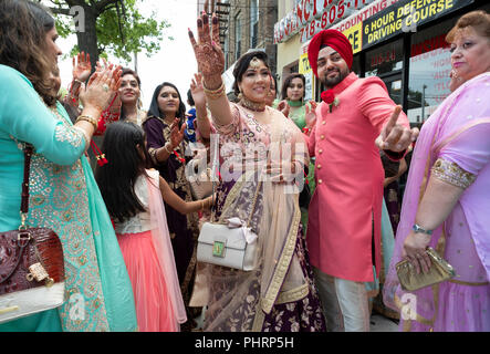 Die Familie & Freunde von einem Sikh Bräutigam feiern Sie mit Gesang und Tanz vor ihm Begleitung Tempel für seine Hochzeit. Stockfoto