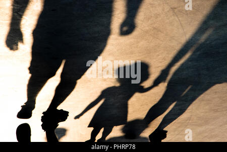 Schatten Silhouette von Mutter und Tochter halten sich an den Händen beim Gehen auf misty Sommer Promenade in sepia schwarz und weiß Stockfoto