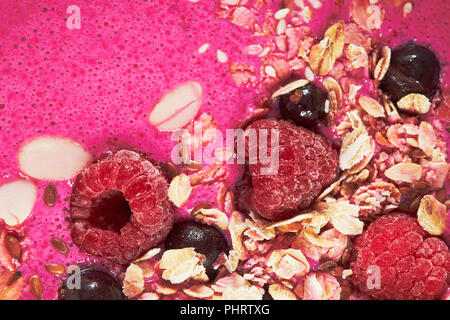 Smoothie gekrönt mit Beeren und Müsli close up Stockfoto