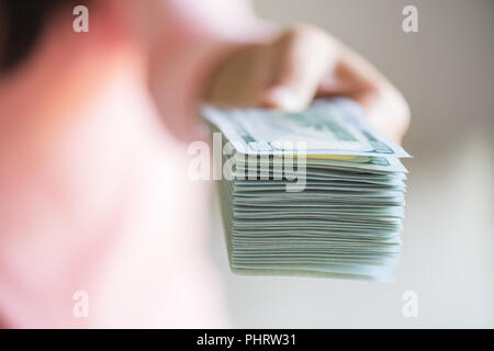 Soft Focus auf Frau Hände, die Sie vorschlagen Geld US-Dollarnoten. Stockfoto