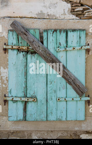 Alte shabby chic geschlossenen Fensters mit Peeling abblätternden Lack und gebrochene Scharniere. Stockfoto