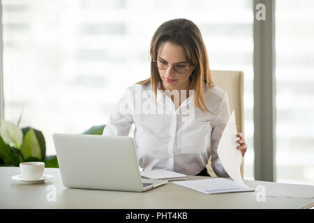 Seriöse Geschäftsfrau arbeiten mit Laptop Dokumente Analyse pr Stockfoto