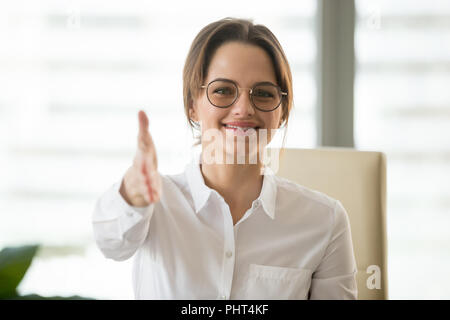 Lächelnd Geschäftsfrau zur Verlängerung der Hand für Handshake an Ca Stockfoto
