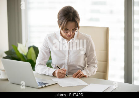 Ernsthafte erfolgreiche Geschäftsfrau stellt Unterschrift auf Business cont Stockfoto