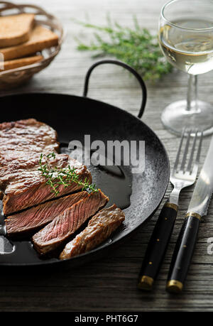 Gegrillte Rindersteaks mit Gewürzen auf hölzernen Tisch Stockfoto