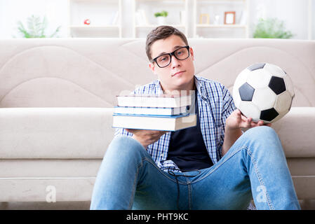 Junge Studenten, die versuchen, zu studieren und spielen Fußball Stockfoto