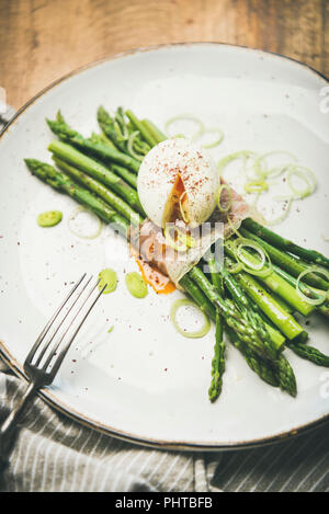 Gesundes Frühstück. Grüner Spargel mit weich gekochten Ei, Lauch und Speck in weißen Platte über rustikal Hintergrund diente, selektiven Fokus Stockfoto