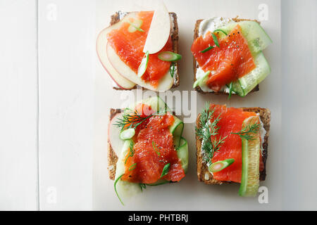 Dänische traditionelle Snack smorrebrod mit Lachs, Gurken und Frischkäse Stockfoto