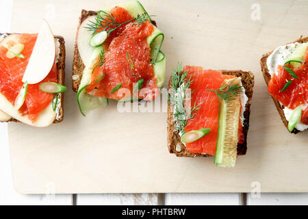 Dänische traditionelle Snack smorrebrod mit Lachs, Gurken und Frischkäse Stockfoto