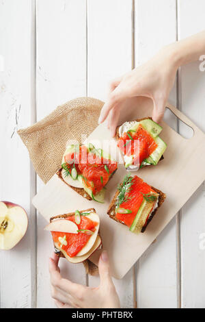 Dänische traditionelle Snack smorrebrod mit Lachs, Gurken und Frischkäse Stockfoto