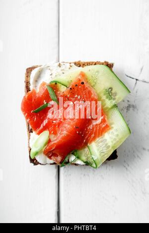 Dänische traditionelle Snack smorrebrod mit Lachs, Gurken und Frischkäse Stockfoto