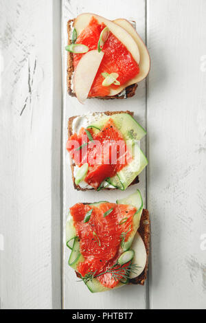 Dänische traditionelle Snack smorrebrod mit Lachs, Gurken und Frischkäse Stockfoto