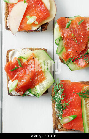 Dänische traditionelle Snack smorrebrod mit Lachs, Gurken und Frischkäse Stockfoto