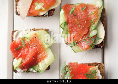 Dänische traditionelle Snack smorrebrod mit Lachs, Gurken und Frischkäse Stockfoto