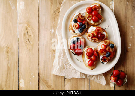 Bruschetta mit Kirsche, Heidelbeere, Honig Sauce und Frischkäse Stockfoto