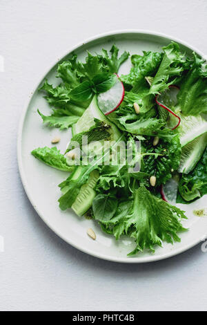 Ansicht von oben Frischer grüner Salat mit Radieschen und Kräutern auf grauem Hintergrund Stockfoto