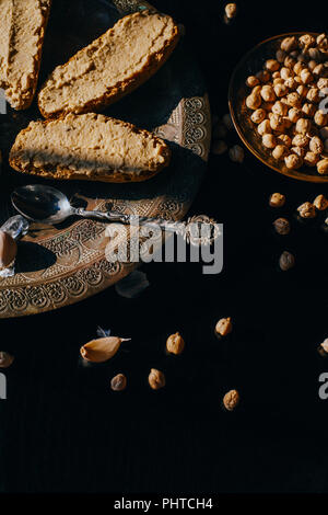 Hausgemachte Hummus auf schwarzem Hintergrund Stockfoto