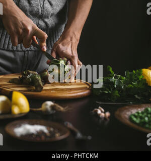 Ein Mann bereitet das Mittagessen mit Artischocken Stockfoto