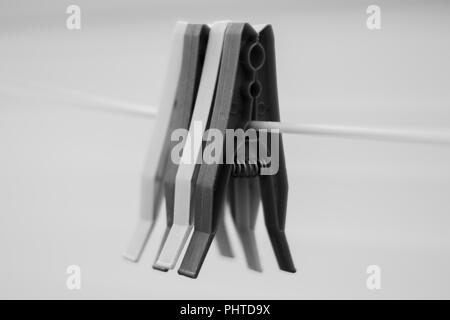 Schwarz und Weiß Schwarzweiß-Foto von alten Kunststoff Peg auf eine Wäscheleine im Freien aufgehängt Stockfoto