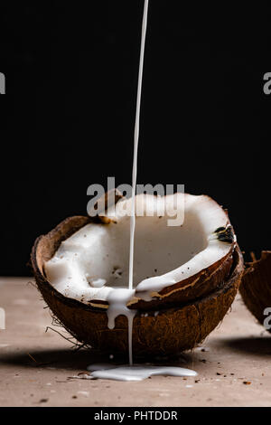 Kokosnuss Milch gießen Stockfoto