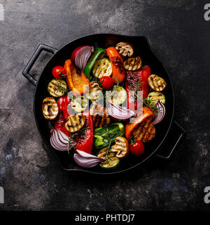 Gegrillte verschiedene Gemüse in gusseisernen Pfanne auf dunklem Hintergrund Stockfoto