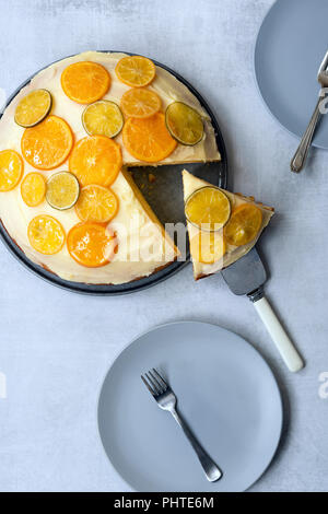Eine runde Iced orange hausgemachte Kuchen mit einem Stück Kuchen auf einem Server. Stockfoto