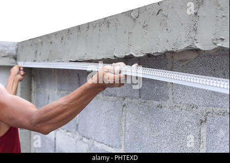 Asiatischer Mann mit einem nassen Beton Wand Stockfoto