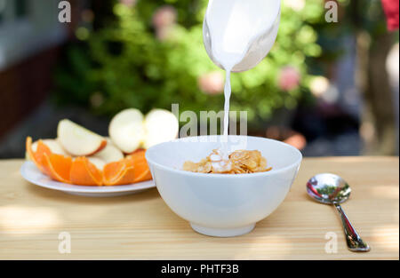 Gießen Milch in die Schüssel Cornflakes Stockfoto
