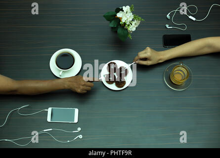 Auf Chocolate Eclair mit Kaffee und Tee Hand Stockfoto