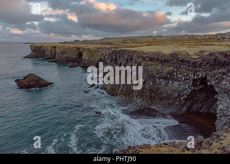 Ein basalt Spalte Shoreline bei Arnarstapi auf der Halbinsel Snaefellsnes in Island in der Dämmerung Stockfoto